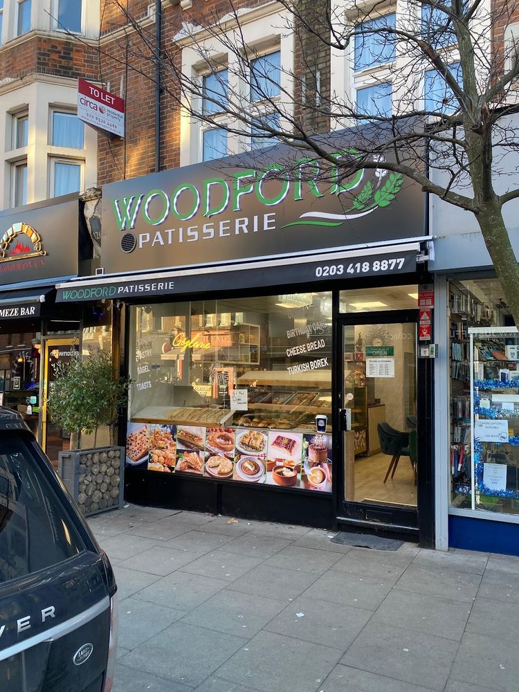 The Woodford Patisserie shopfront with its awning and window display of cakes