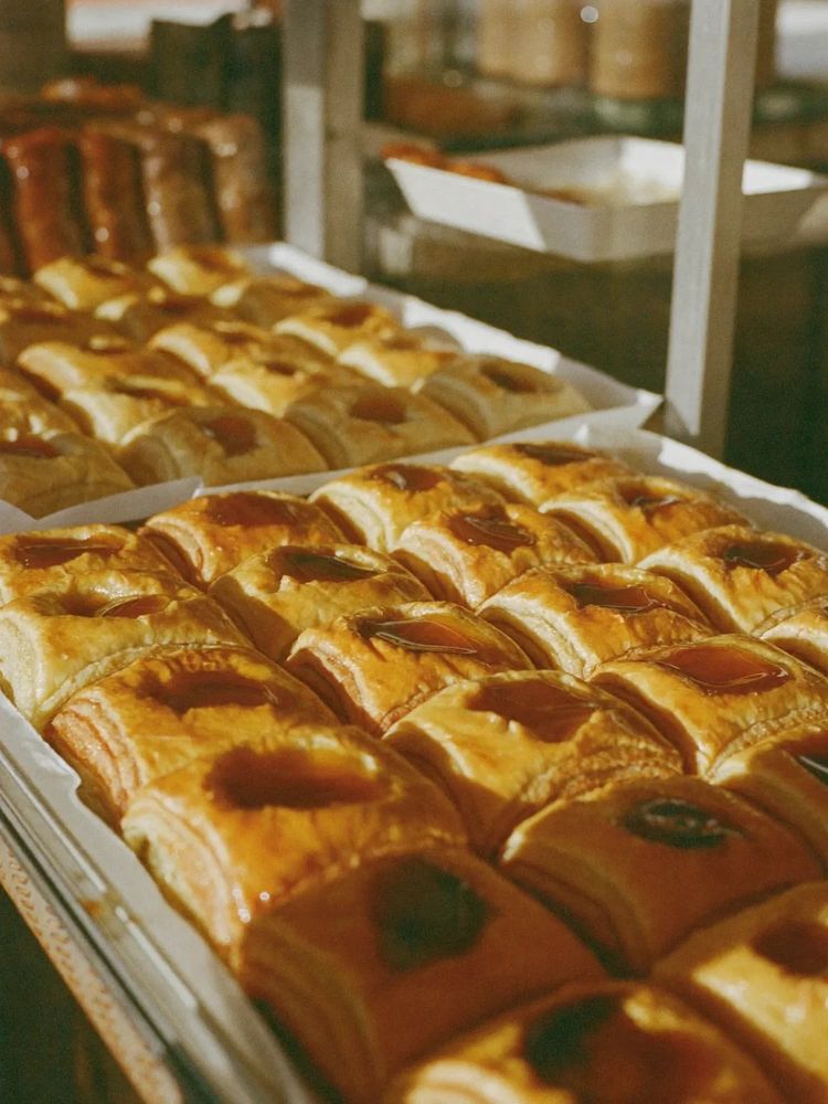 Trays of baklava and syrup pastries in rows behind the counter glass